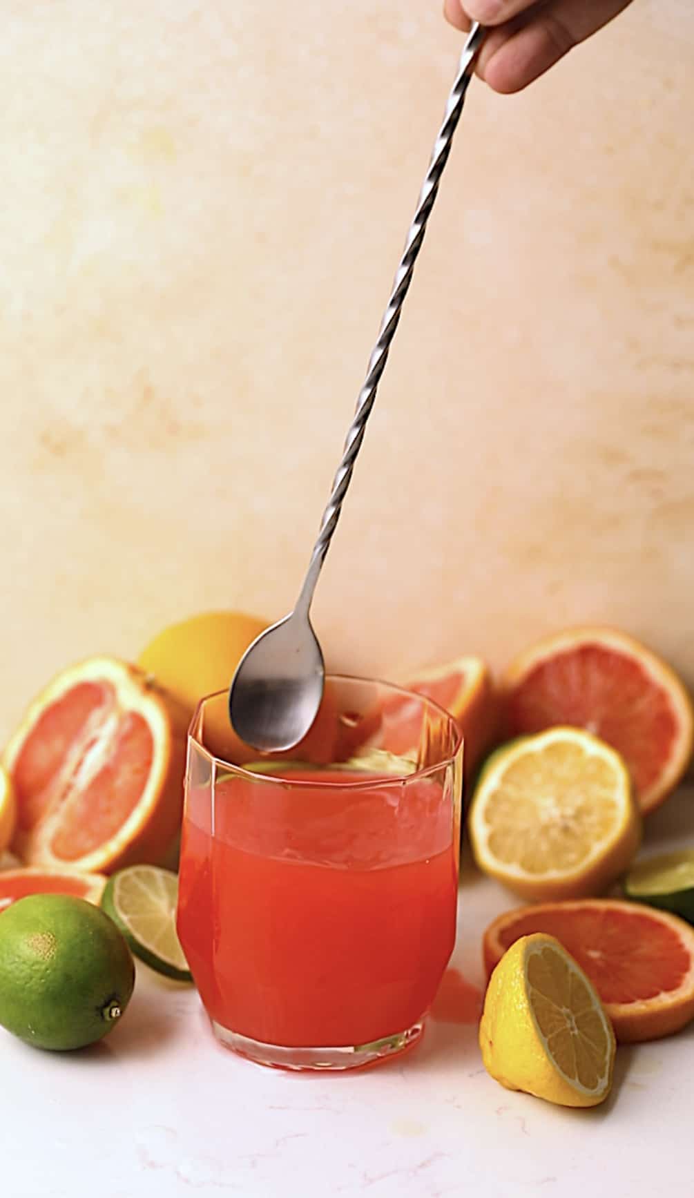 A cocktail stirrer mixing a bahama mama in a cocktail glass.
