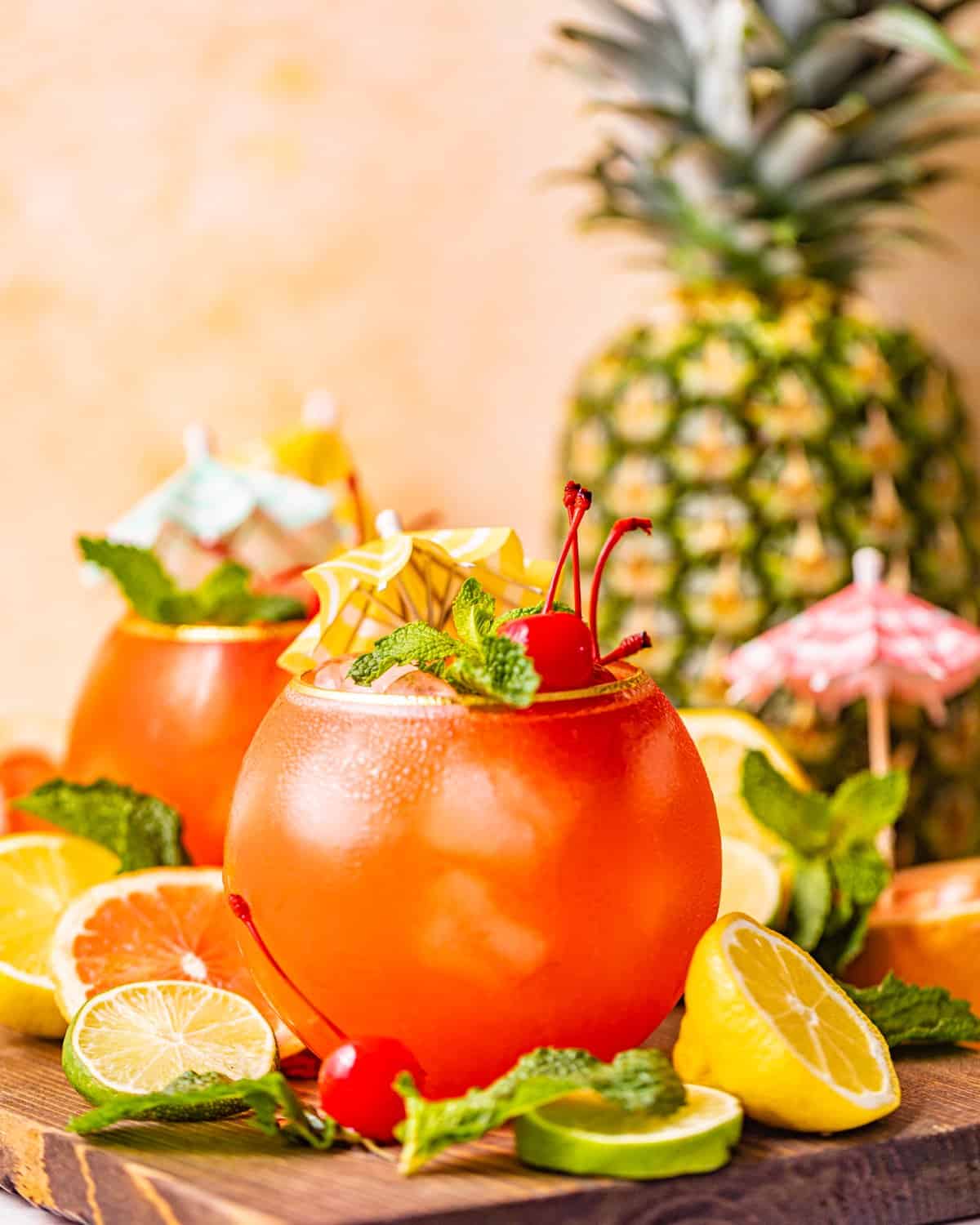 bahama mama cocktail on a brown tray with sliced lemons and limes