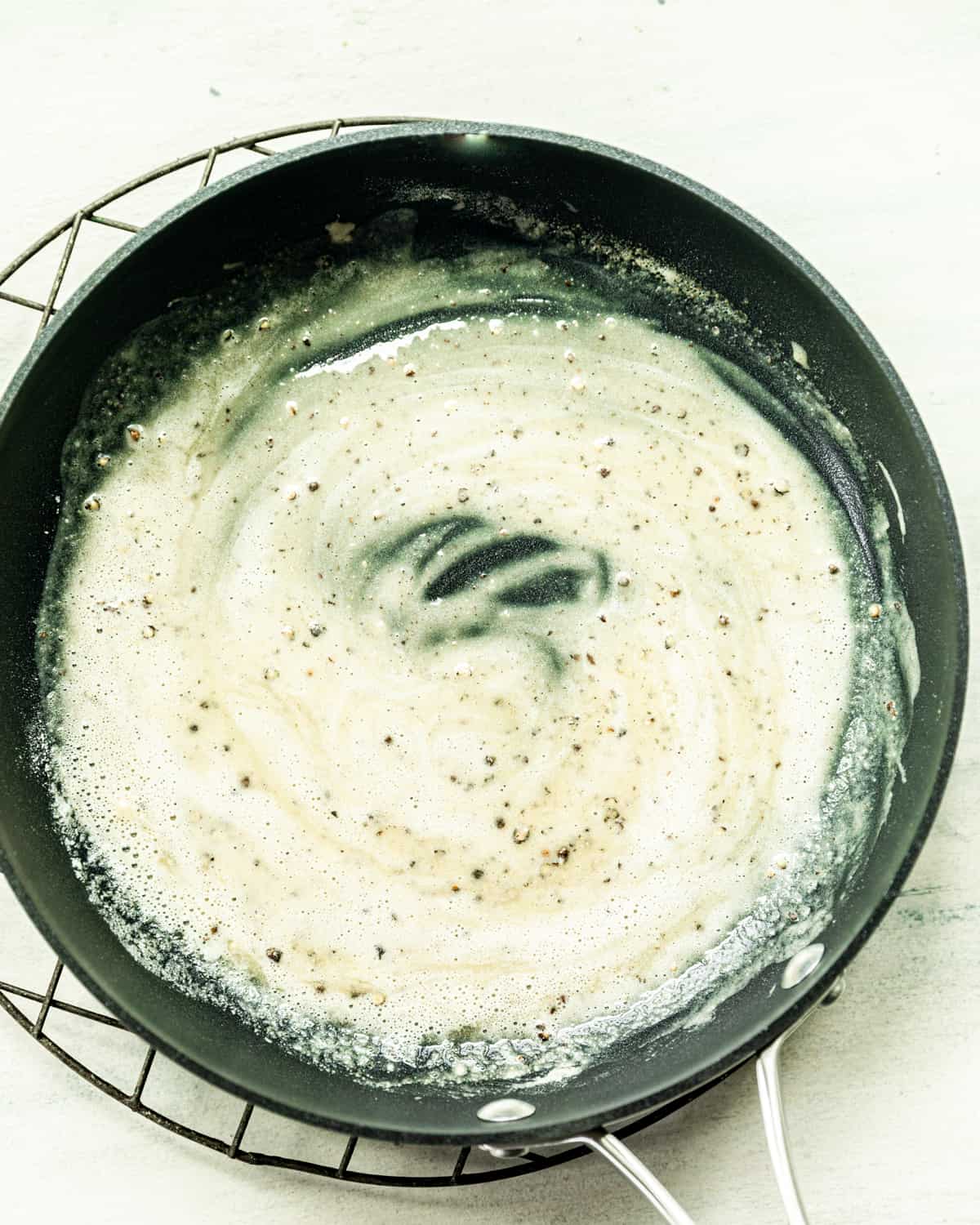 flour, milk, pepper, and pecorino cheese in a pan.