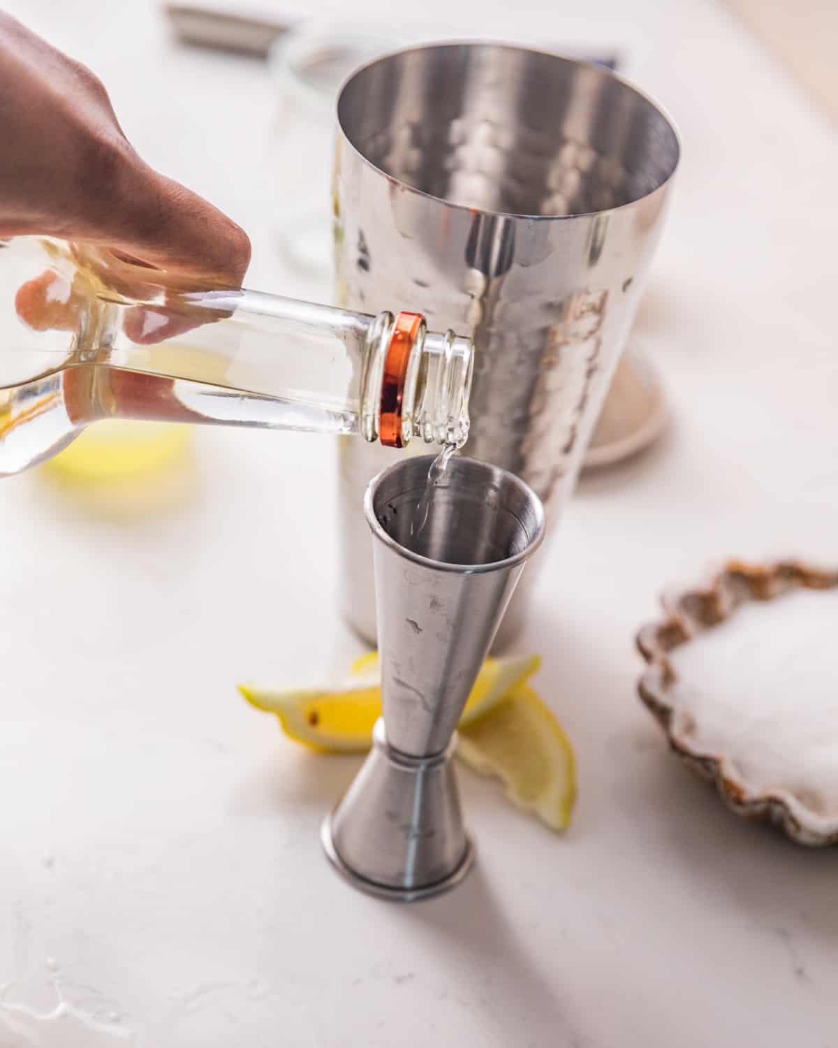 Pouring vodka into a jigger prior to adding to a cocktail shaker.