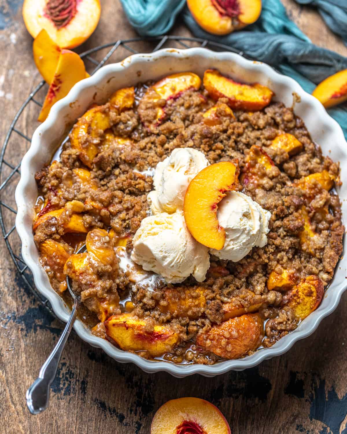 peach crumble in a pie pan with a spoon.