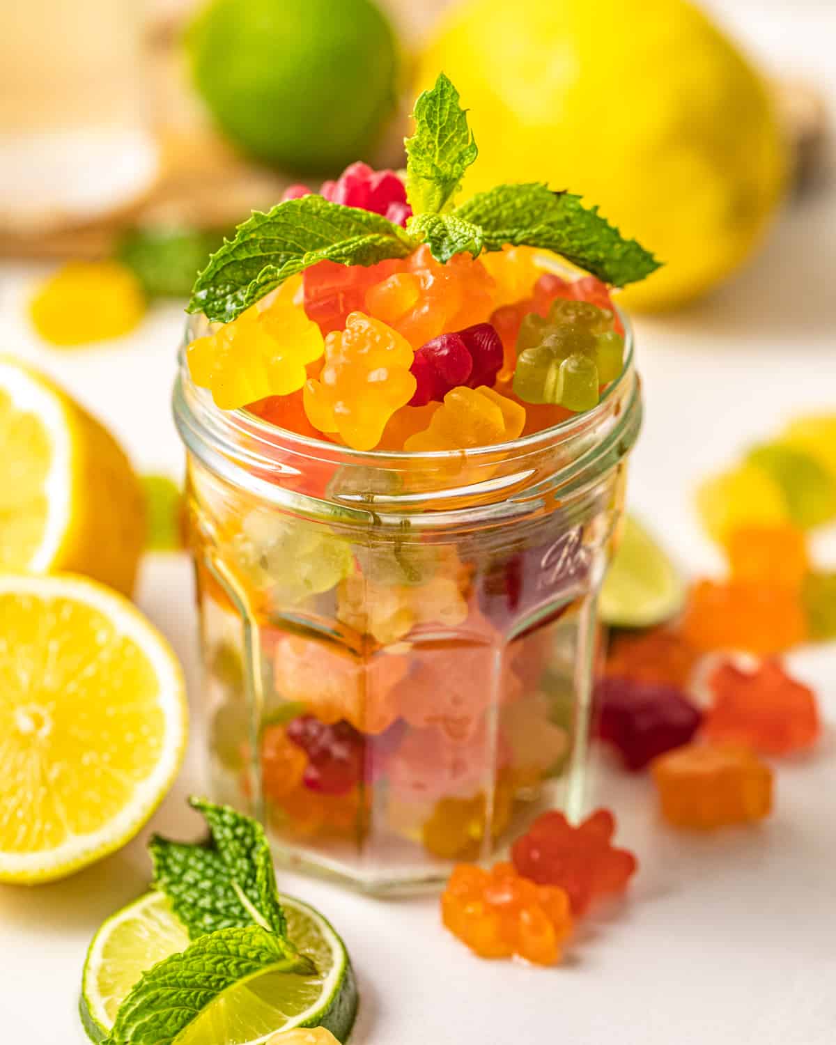 a jar of gummy bears with a mint leaf on top.