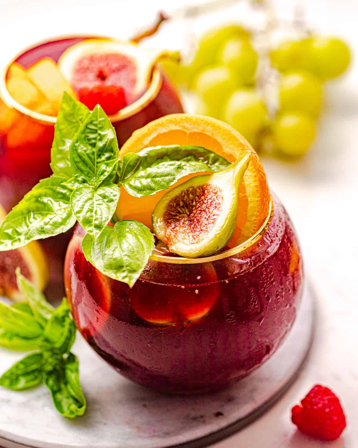bourbon sangria in a glass with fresh figs, basil, and orange slices.