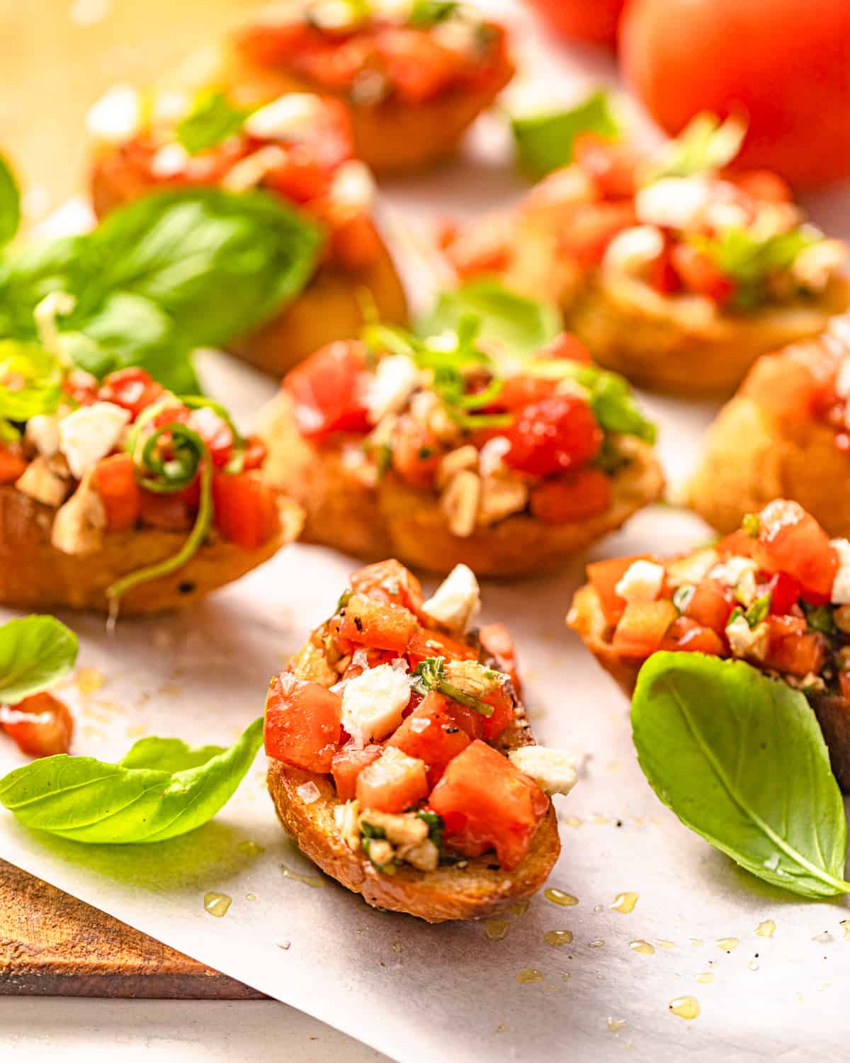 bruschetta with mozzarella topped with fresh basil on a wooden board.
