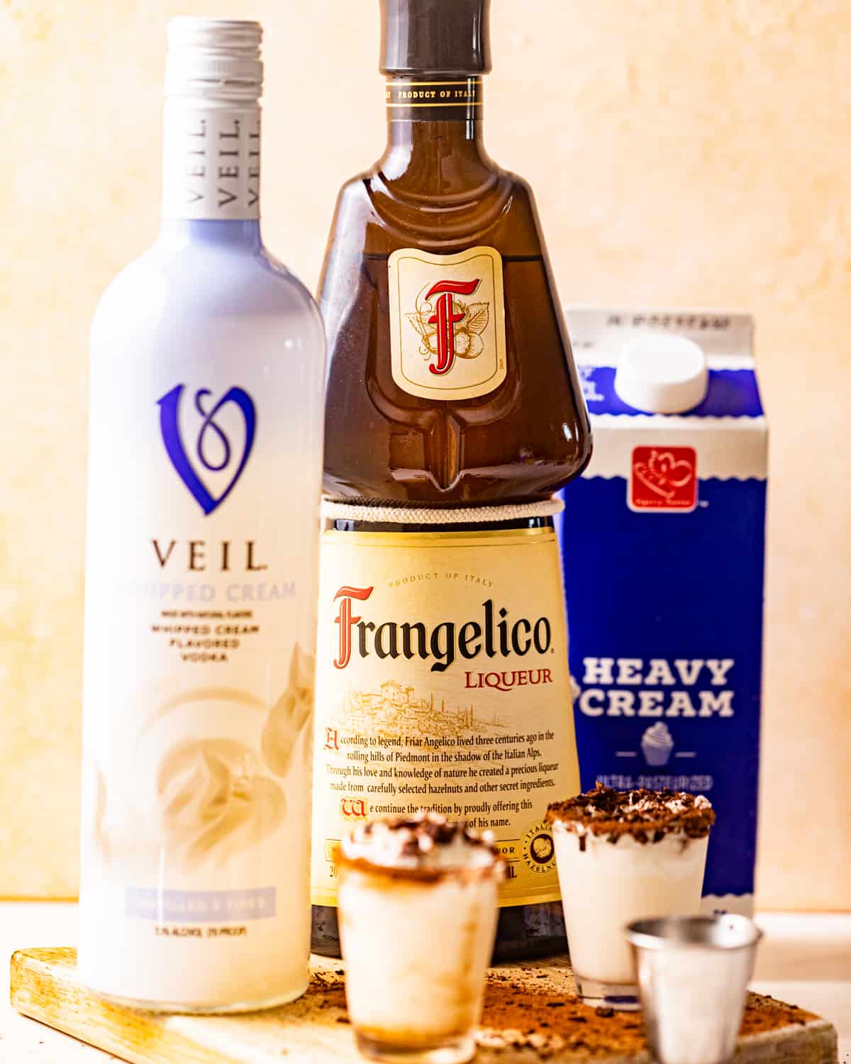 ingredients to make a chocolate cake shot - vodka, hazelnut liqueur, and heavy cream.