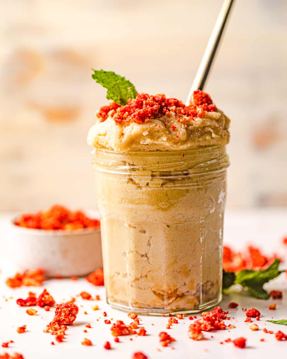 edible sugar cookie dough in a jar with strawberry crumbles on top.