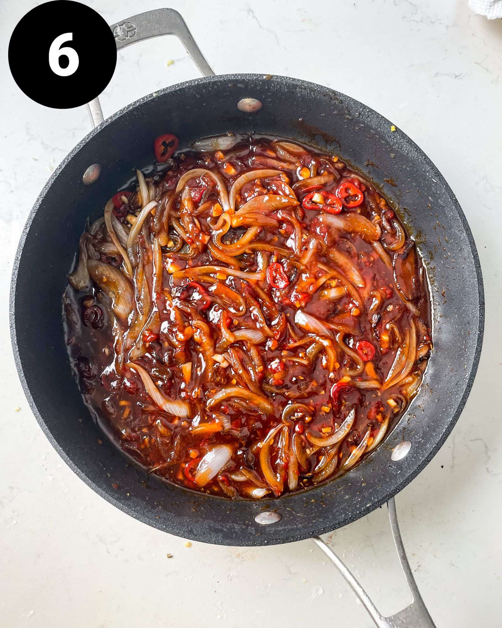 sweet chilli sauce in a pan with onions and chillies,