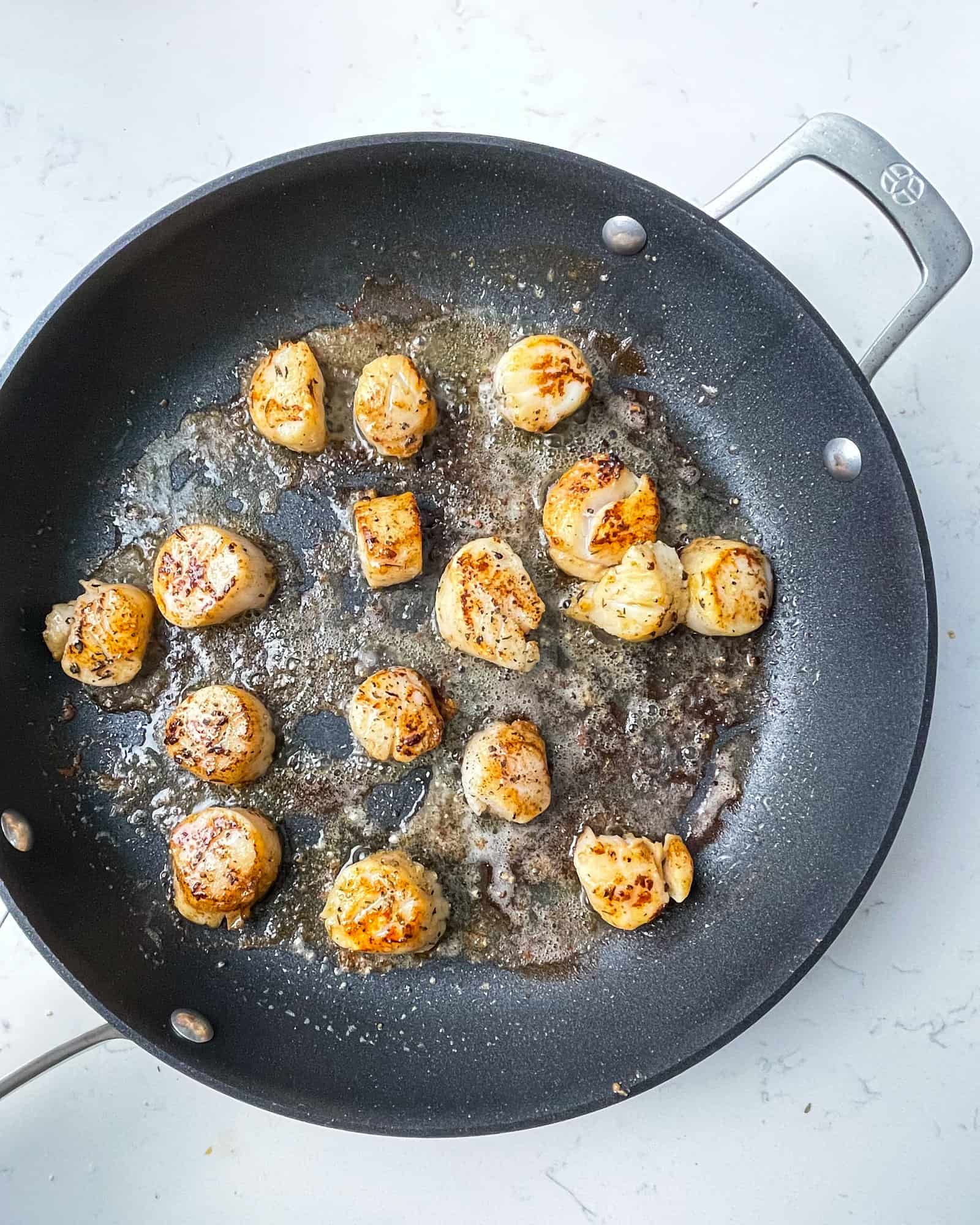 seared scallops in a frying pan.