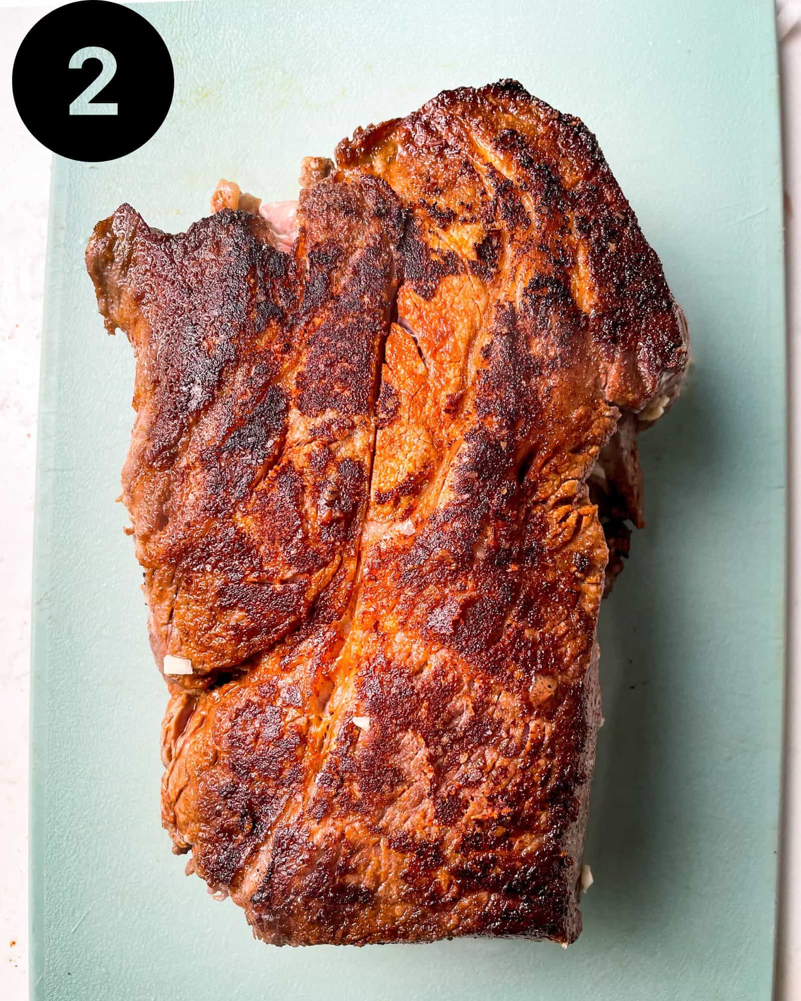seared chuck roast on a cutting board.