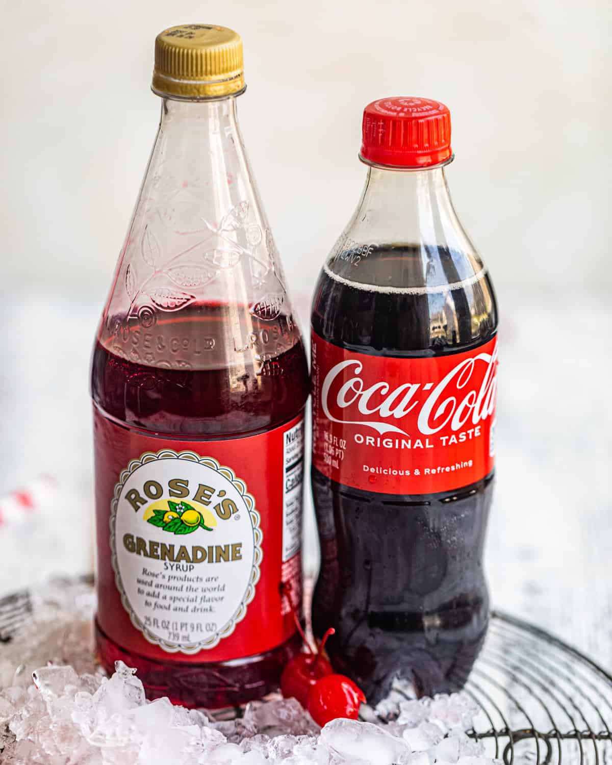 ingredients to make a Roy Rogers drink - coca-cola, grenadine, and maraschino cherries.