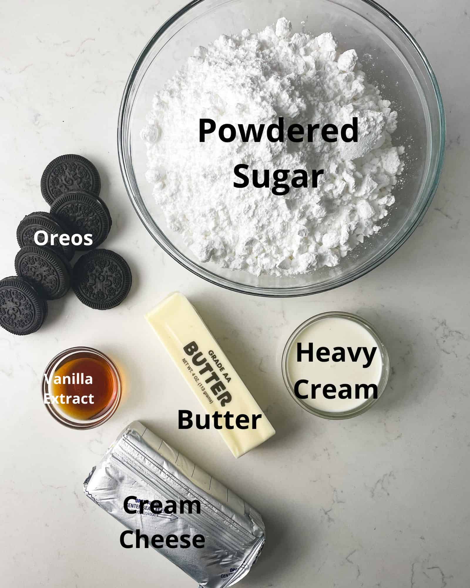 ingredients to make oreo frosting - powdered sugar, butter, cream cheese, heavy cream, oreos, and vanilla extract.