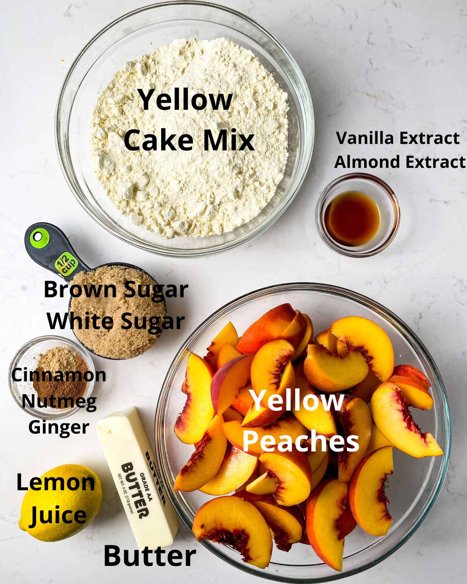 ingredients to make peach cobbler with cake mix - yellow cake mix, yellow peaches, brown sugar, white sugar, vanilla extract, almond extract, cinnamon, nutmeg, ginger, butter, and lemon juice.