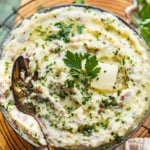 red skin mashed potatoes in a bowl garnished with fresh parsley.