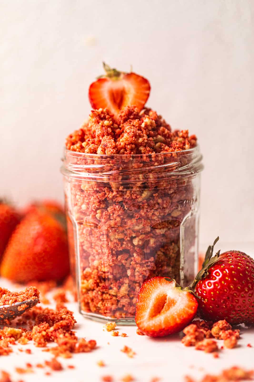 strawberry shortcake crumbles in a jar topped with strawberries.