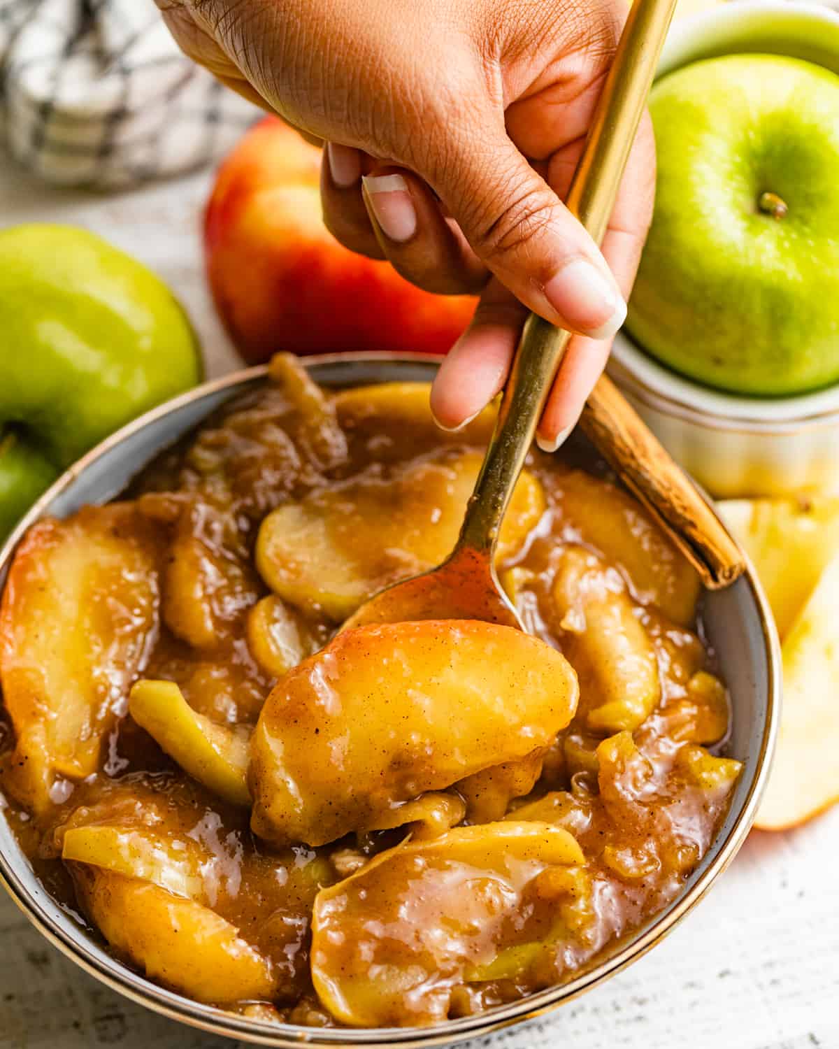 a spoon in a bowl of apple pie filling.