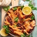 cajun salmon pasta in a bowl on top of a serving board.