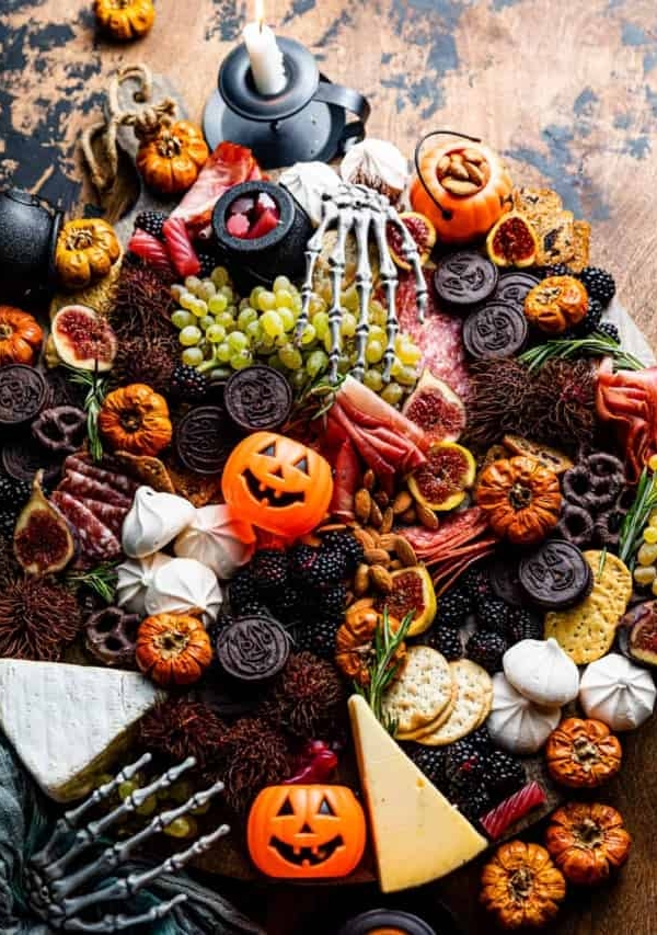 a halloween charcuterie board on a table with halloween decorations.