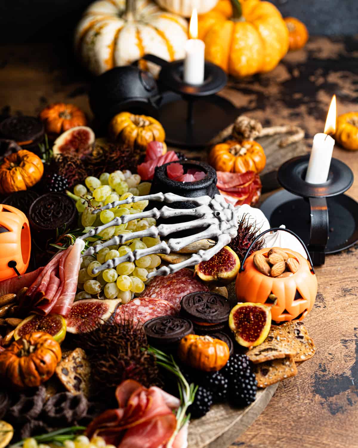 halloween cheese board on a table with candles.