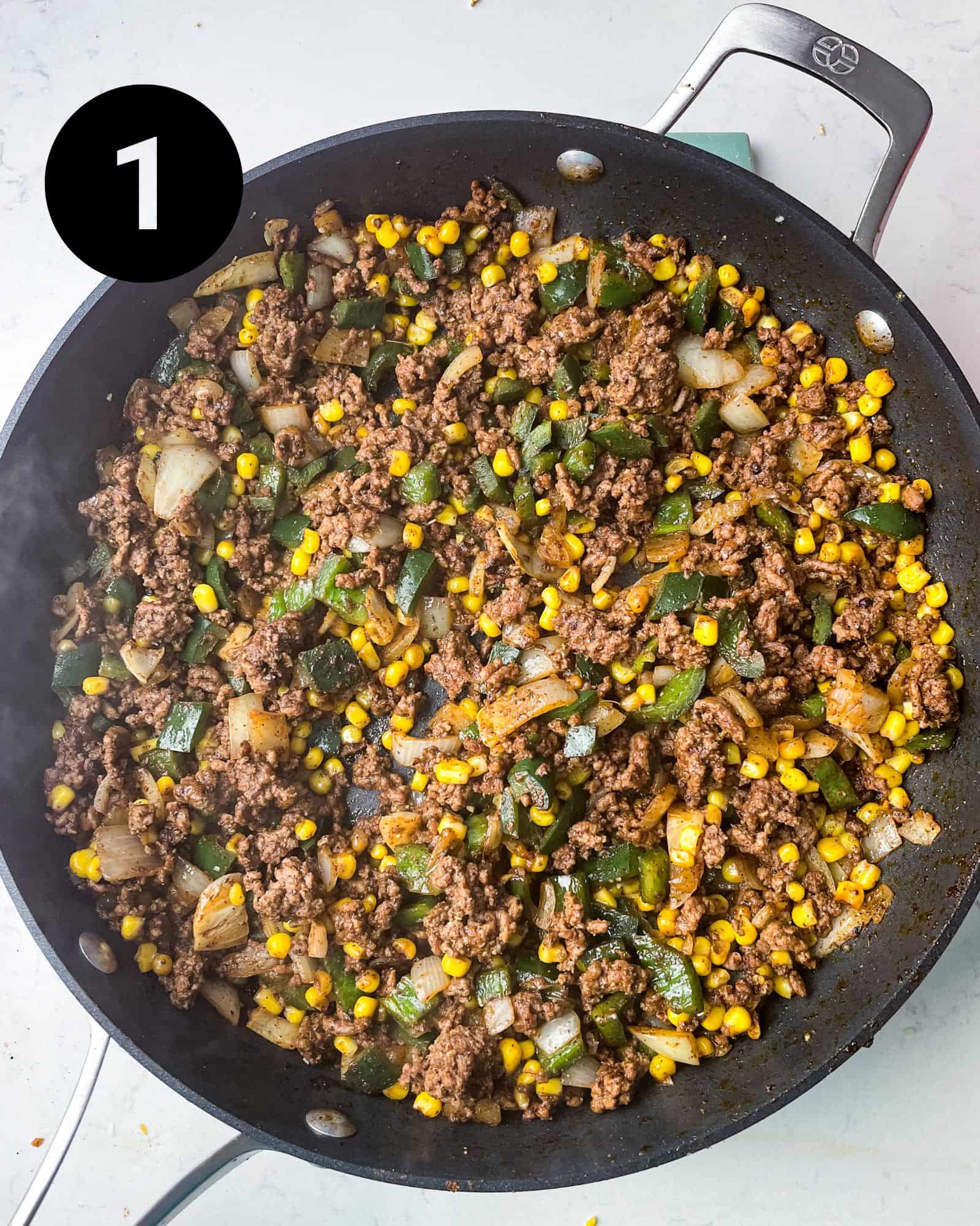 ground beef, onions, peppers, corn, and seasonings in a large pan.