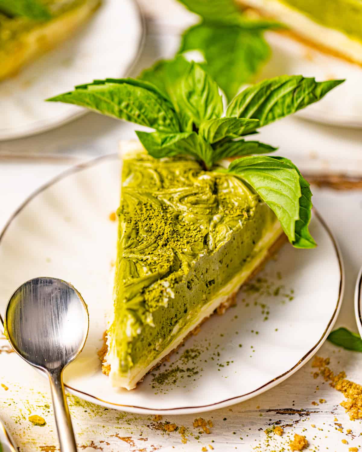a slice of green tea cheesecake on a plate with a spoon.