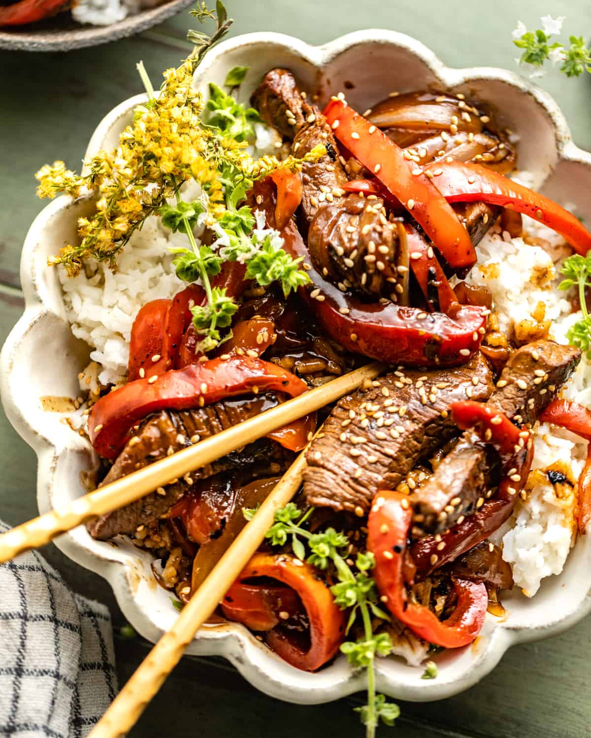 pepper steak recipe in a bowl with chopsticks.