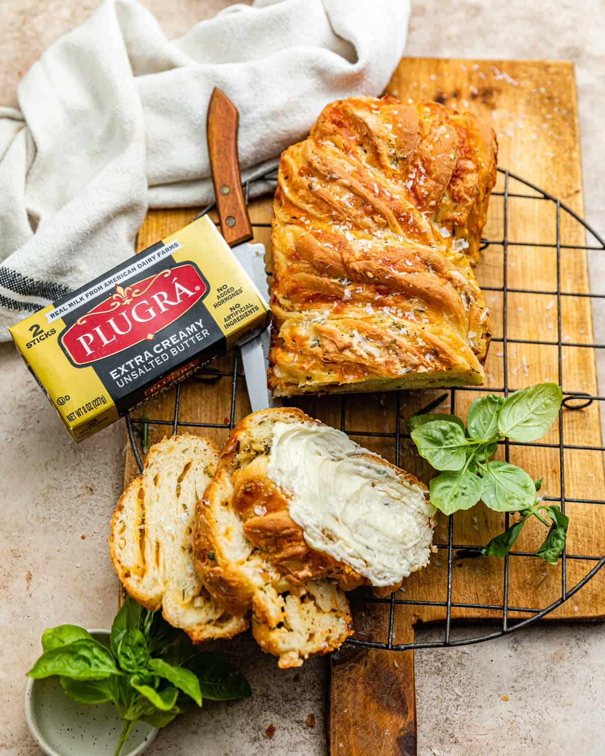 cheese babka on a cooling rack with a kitchen towel.