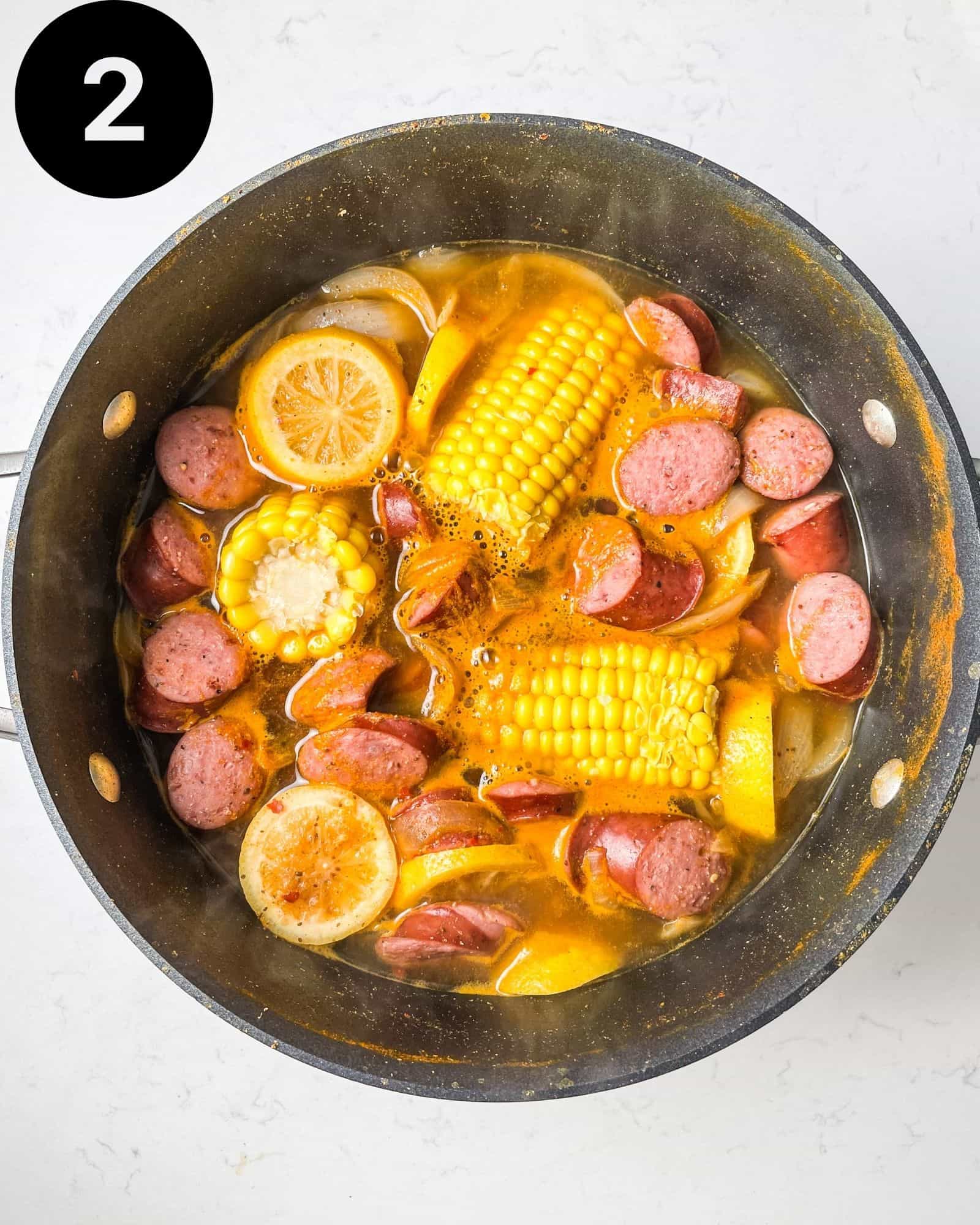 potatoes, corn, sausage, and shrimp boil broth in a large pot.