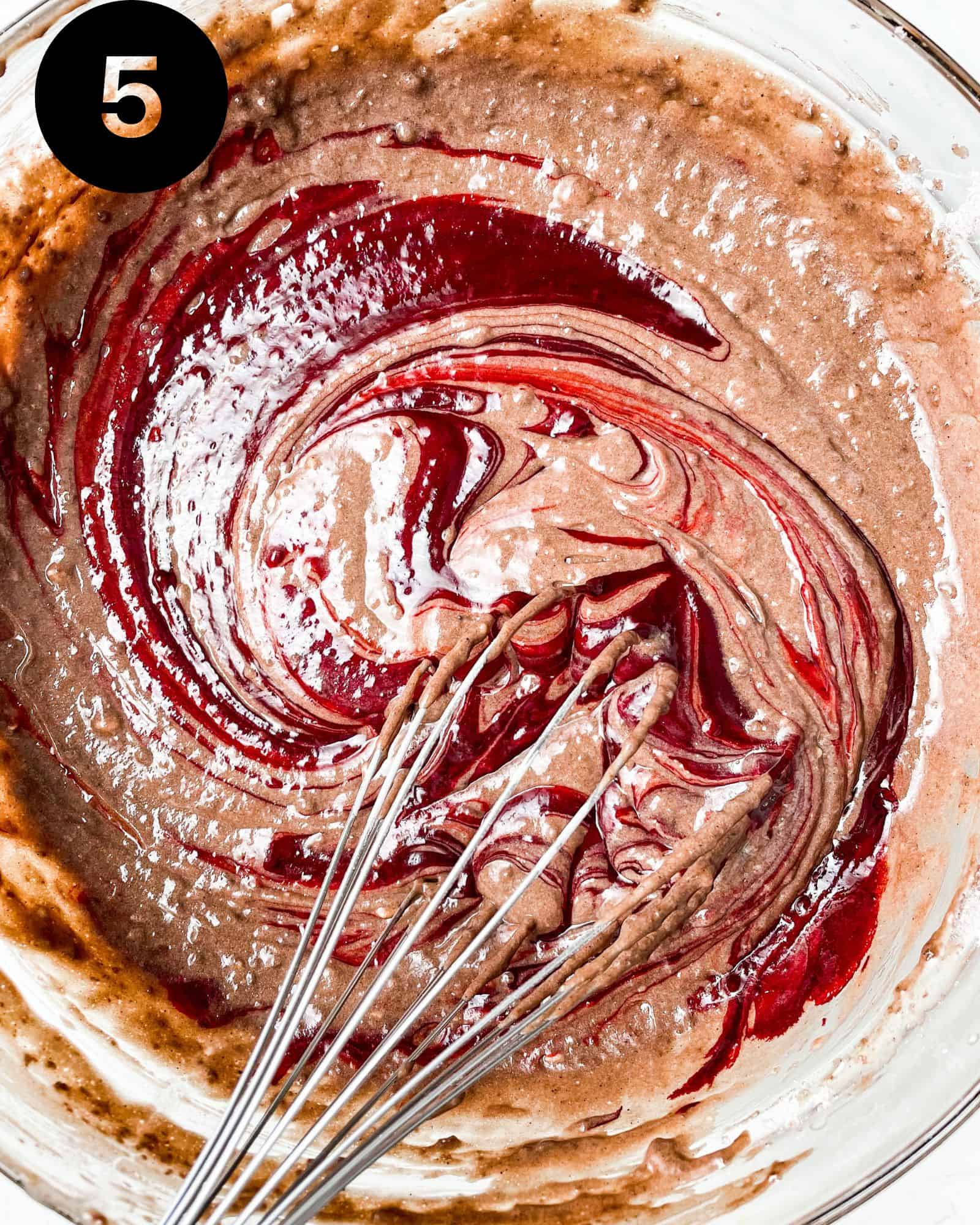 cake batter with red food coloring mixed inl.