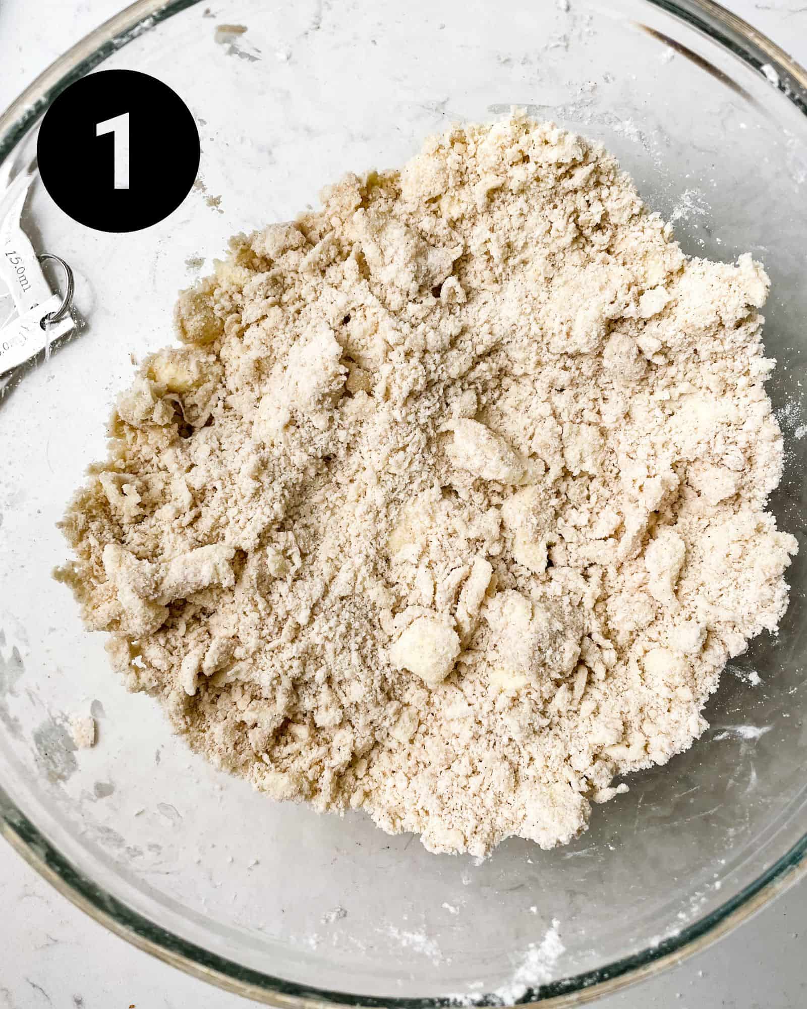 flour, sugar, salt, and butter mixed together in a bowl to create the flaky pie crust.