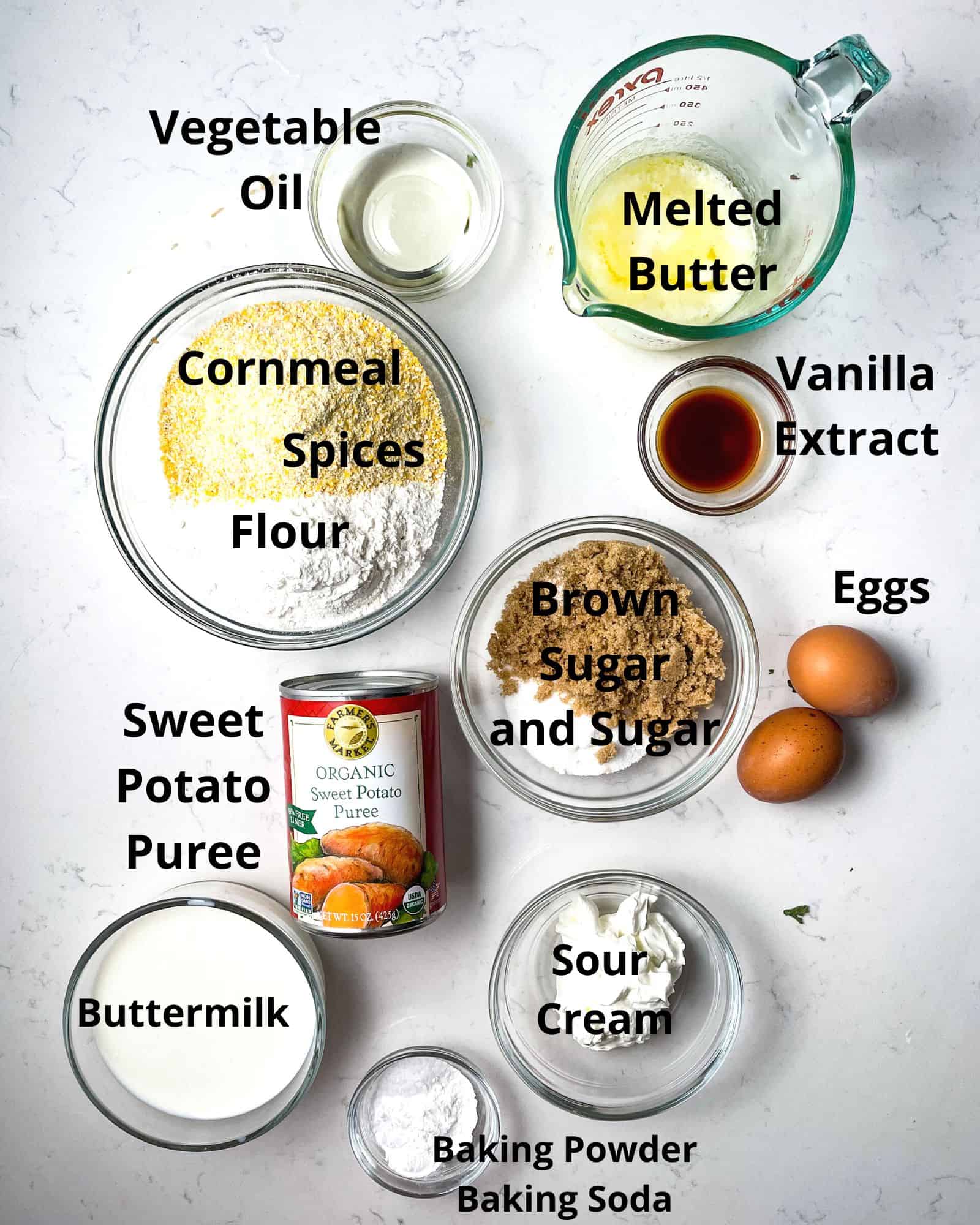 ingredients to make sweet potato cornbread - flour, cornmeal, spices, brown sugar, sugar, baking soda, baking powder, sour cream, buttermilk, butter, vanilla extract, and eggs.