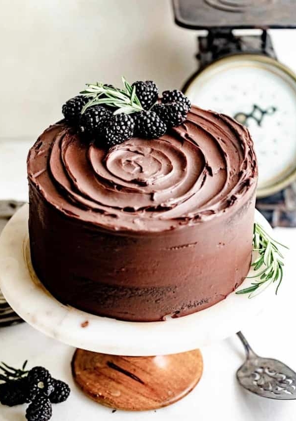 chocolate ganache cake on a cake stand.