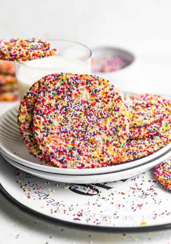 sprinkle sugar cookies in front of a glass of milk.