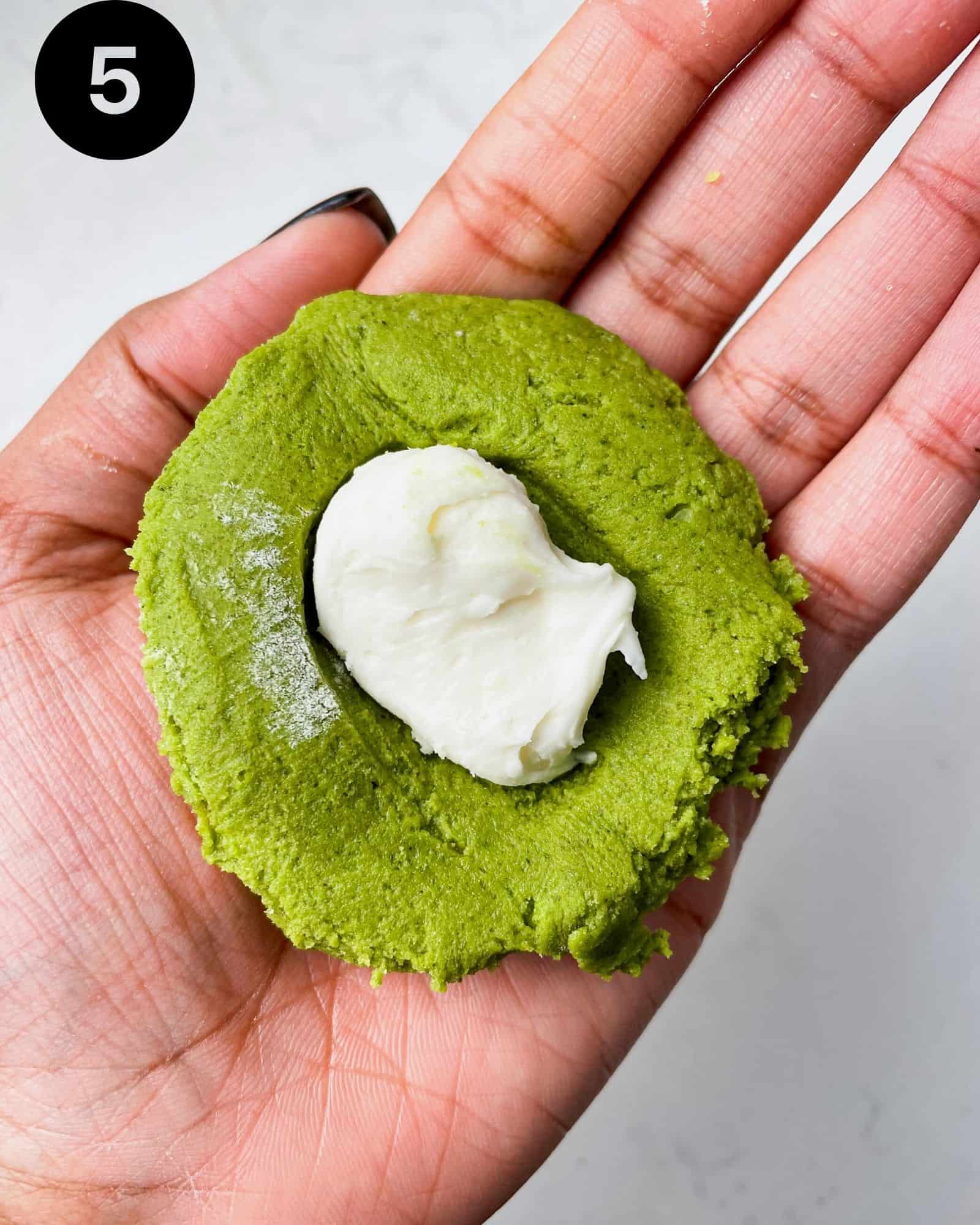 a matcha cookie filled with cream cheese and white chocolate.
