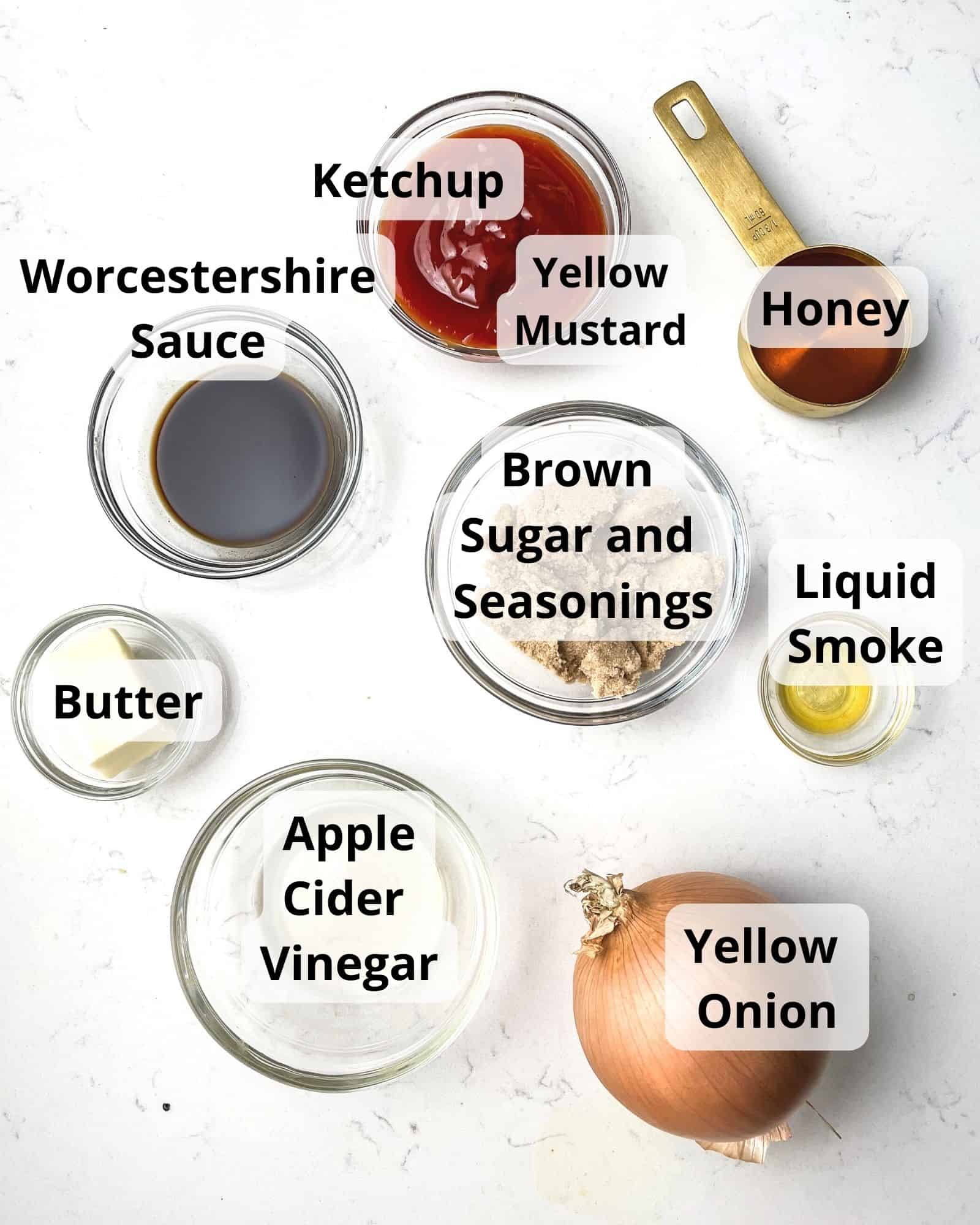ingredients to make honey bbq sauce - onion, honey, worcestershire sauce, liquid smoke, ketchup, apple cider vinegar, brown sugar, smoked paprika, chili powder, black pepper, yellow mustard, and butter.