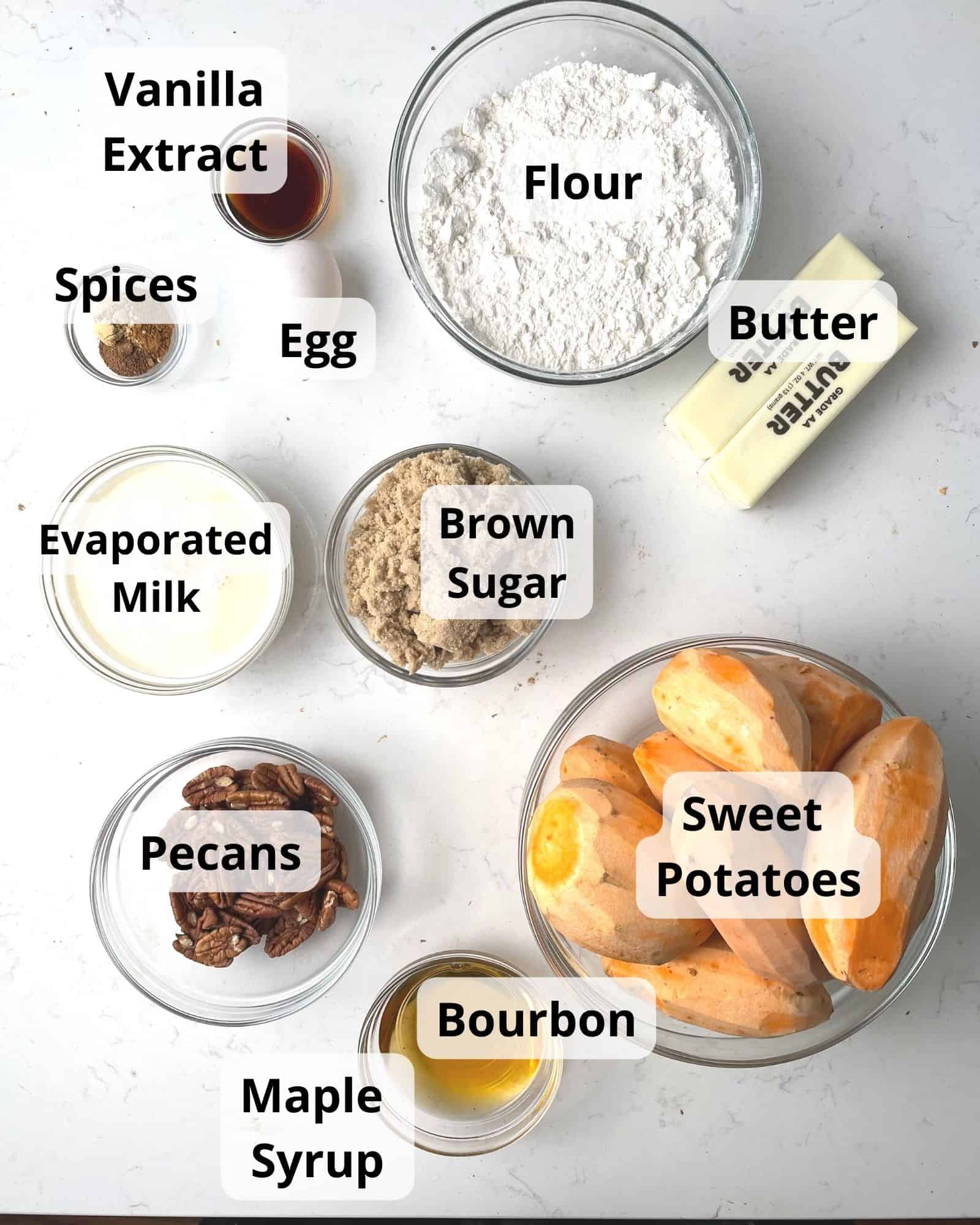 ingredients to make bourbon sweet potato casserole - butter, pecans, brown sugar flour, cinnamon, nutmeg, sweet potatoes, ginger, bourbon, maple syrup, evaporated milk, vanilla extract, and an egg.