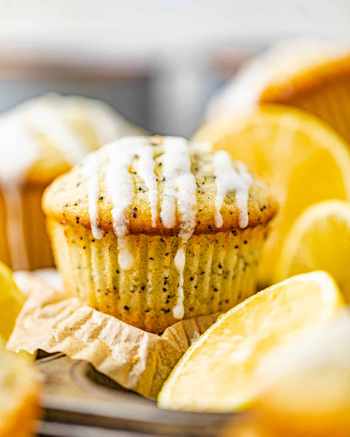 lemon poppy seed muffins next to sliced lemons.