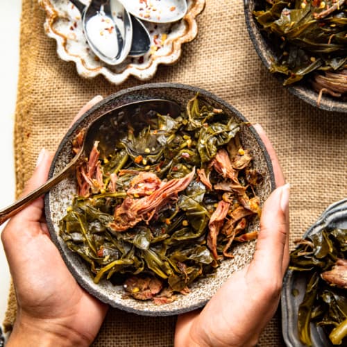 slow cooker collard greens in a bowl with a spoon.