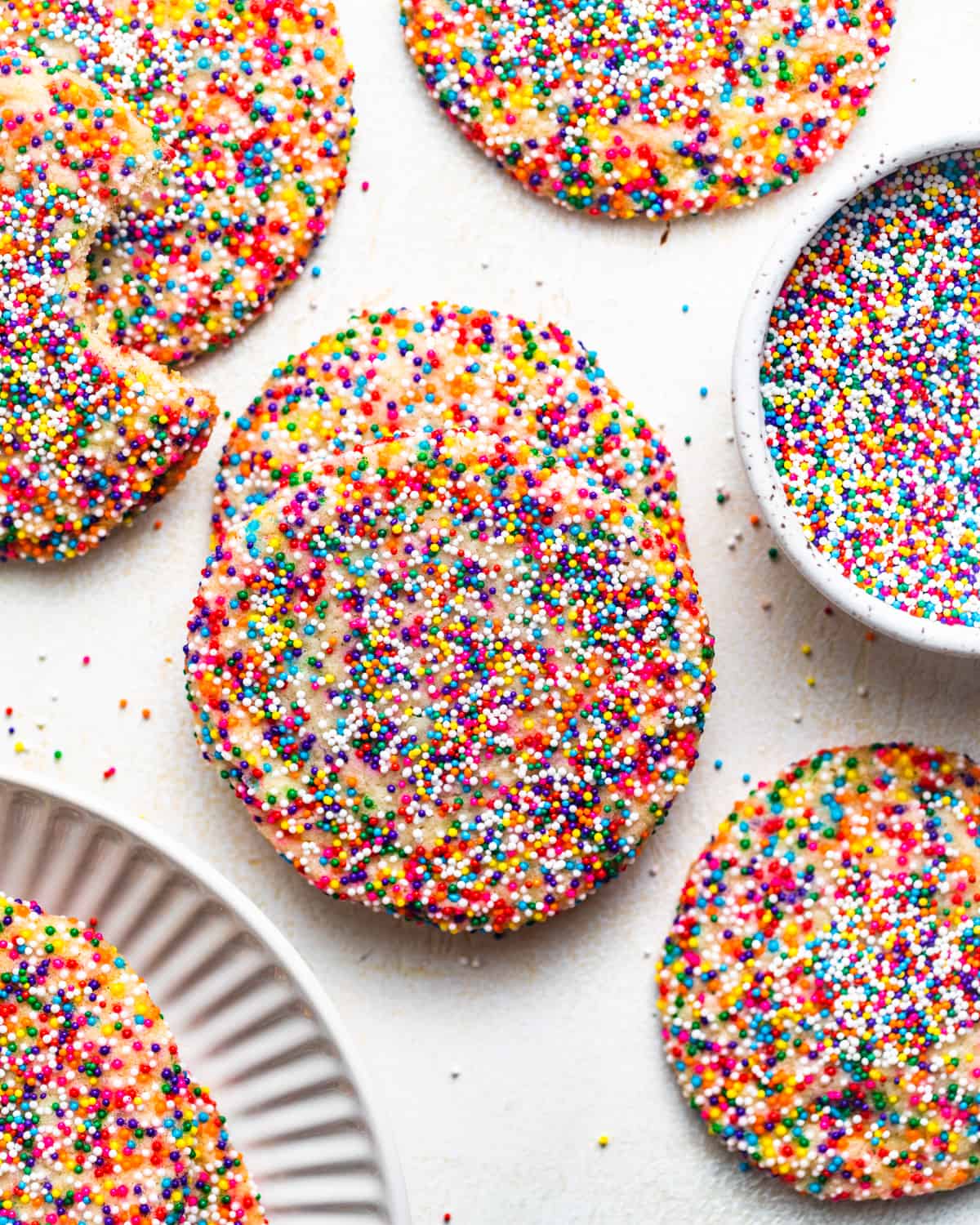 sprinkles cookies on a white surface.