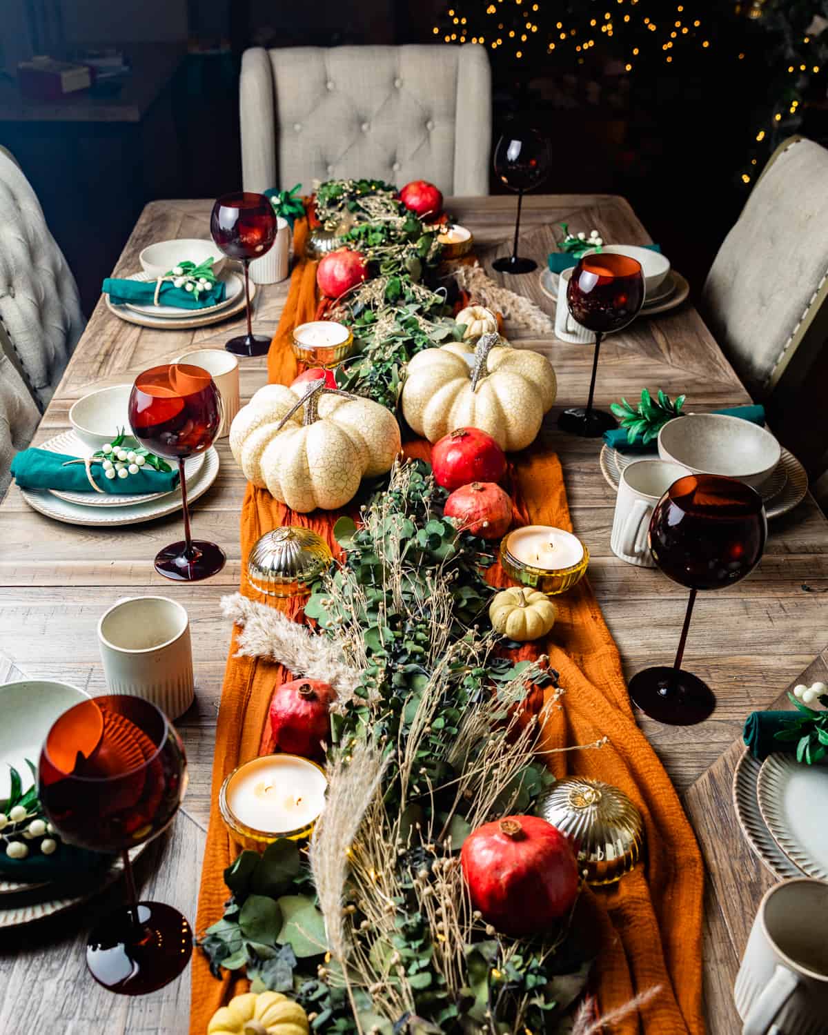 thanksgiving table set with garland and pumpkins.