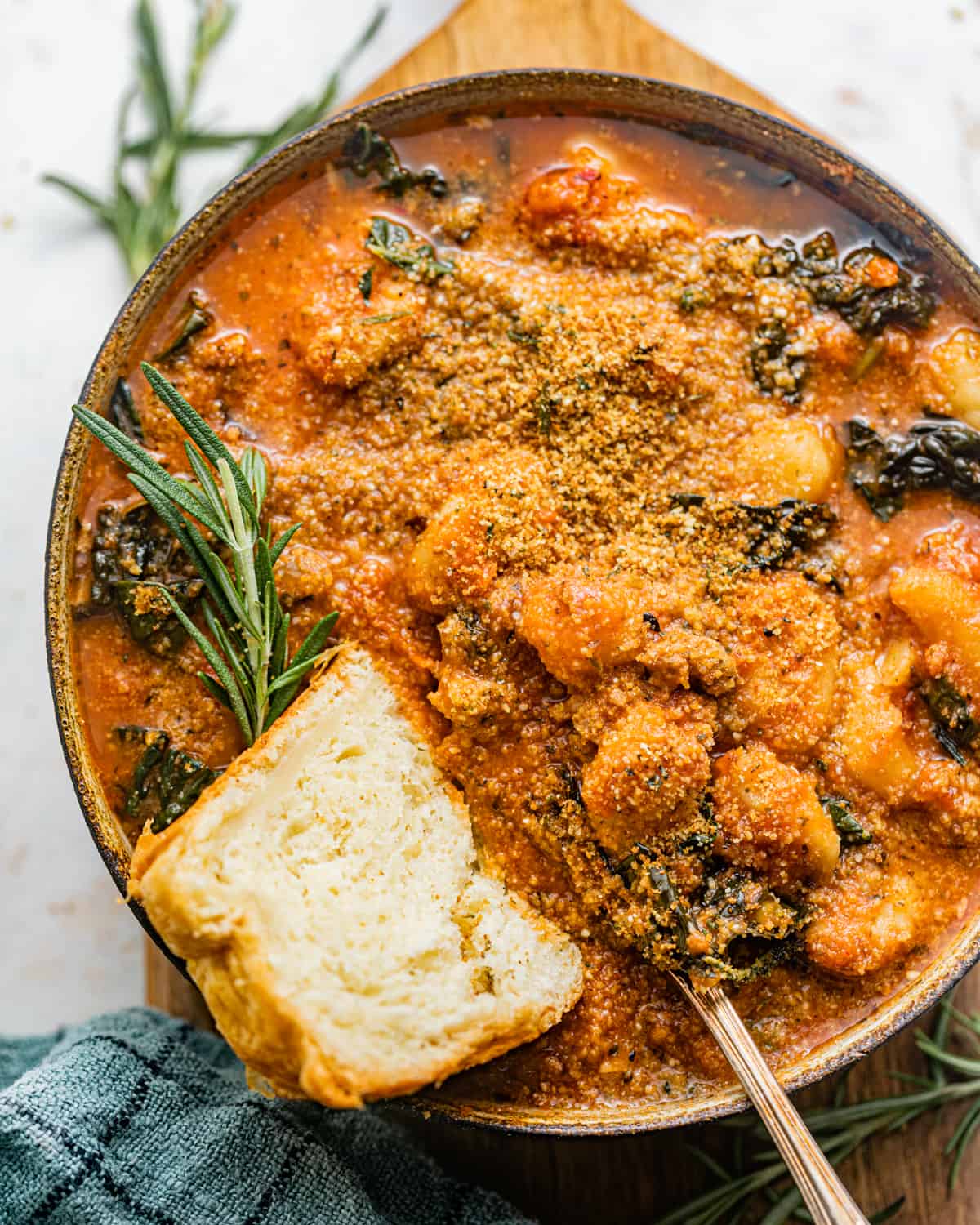 tomato gnocchi soup in a bowl with a piece of bread.