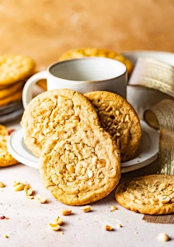chewy peanut butter cookies on a plate with a mug.
