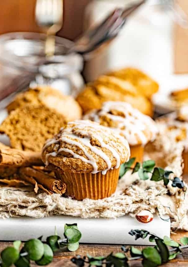 a gingerbread muffin on a tablecloth in front of a glass jar.