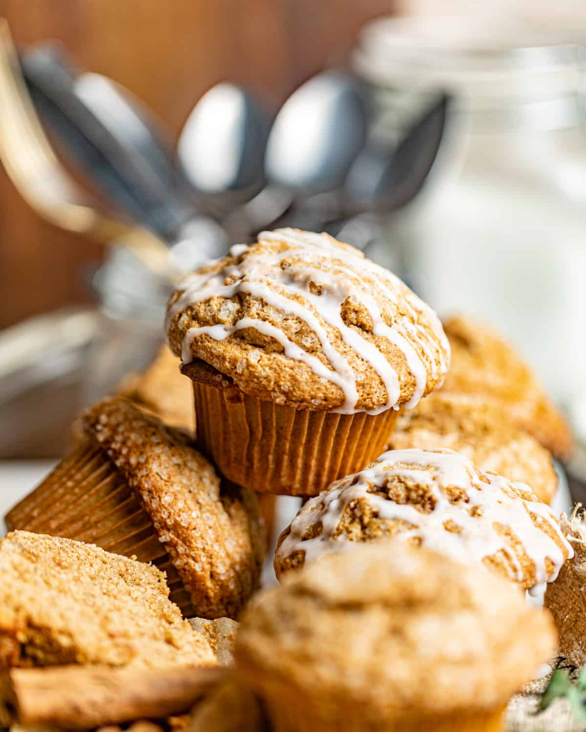 gingerbread muffins stacked on top of one another in front of a jar of spoons.