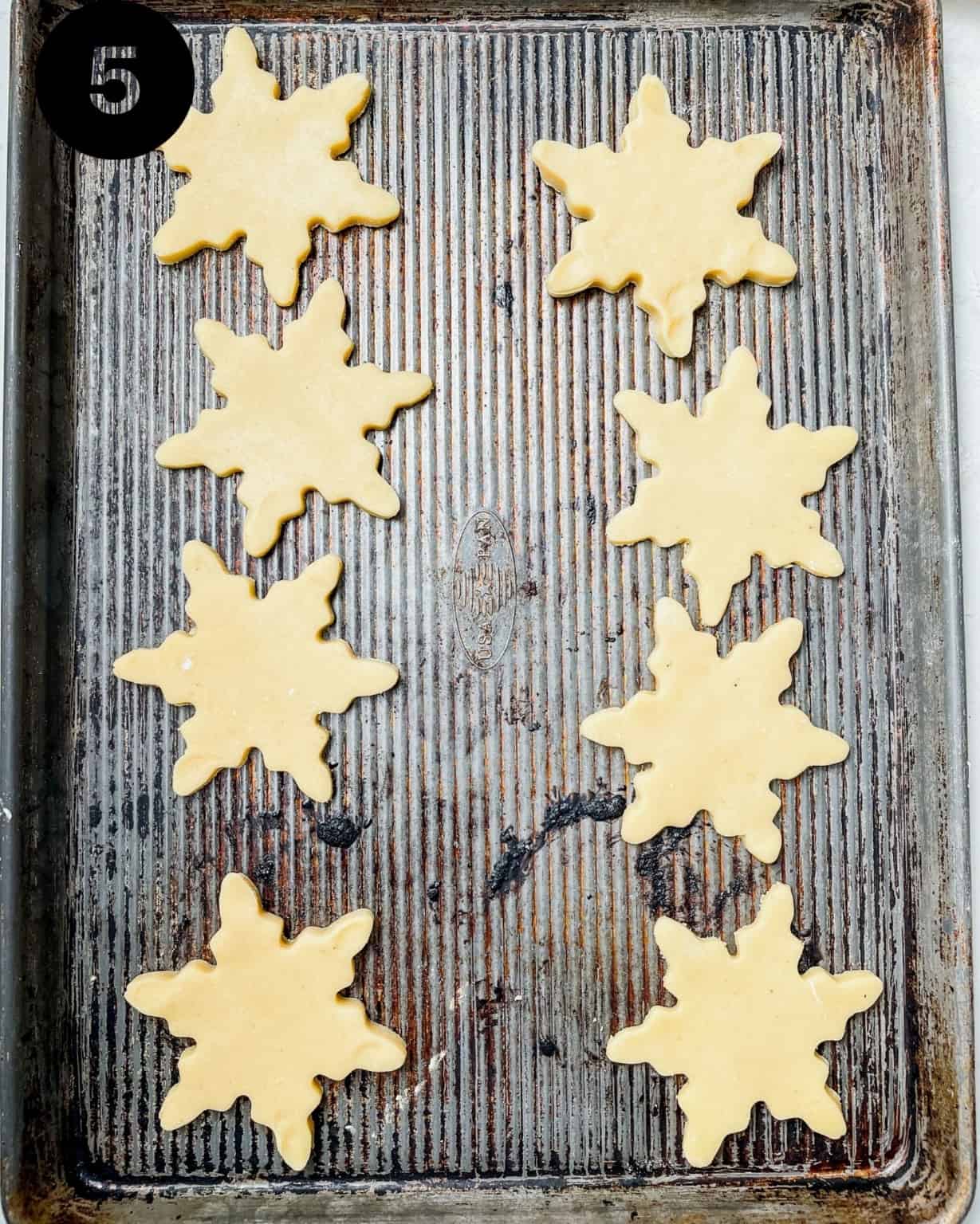 snowflake cookies on a baking sheet.