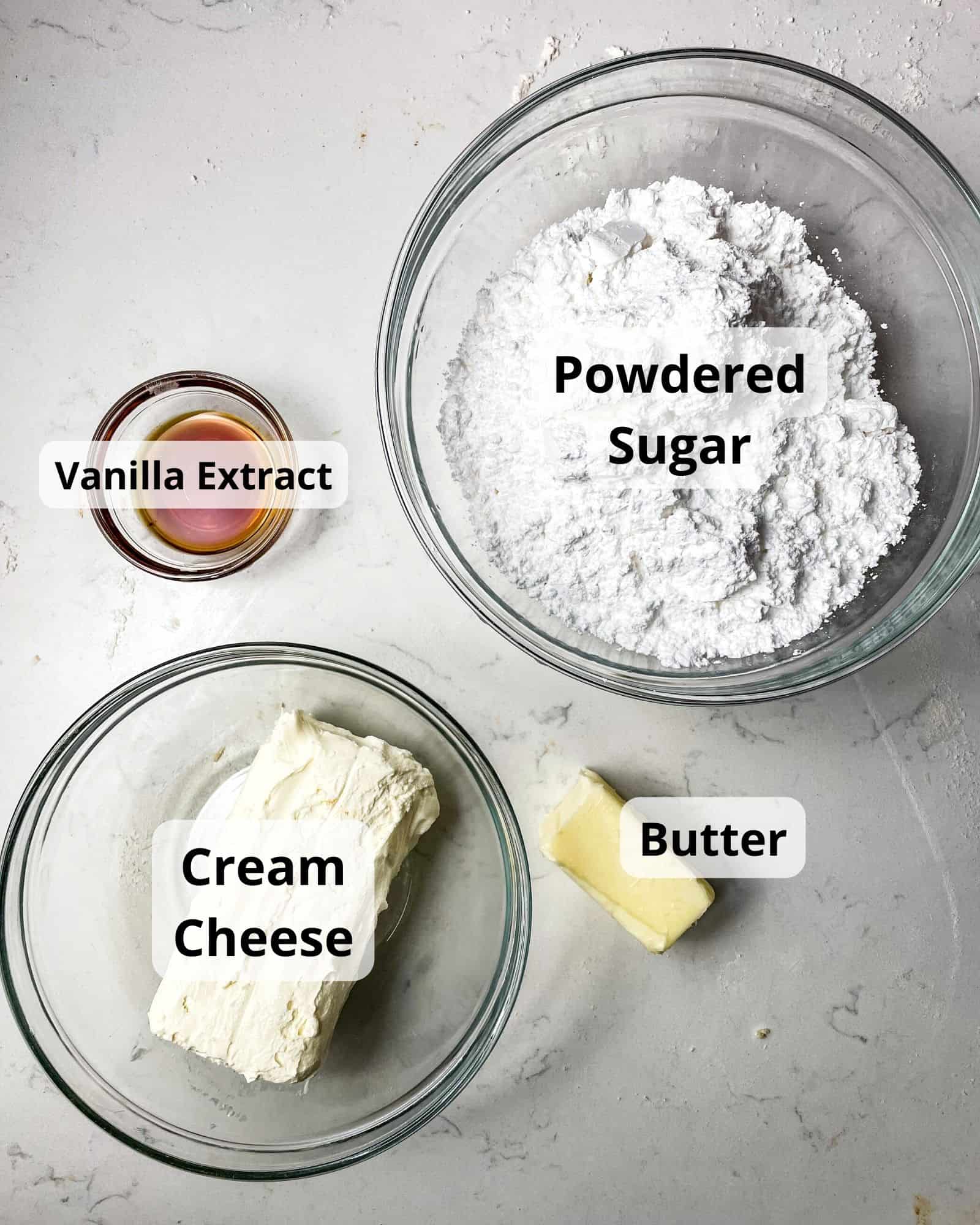 ingredients to make cream cheese icing - cream cheese, butter, powdered sugar, and vanilla extract.