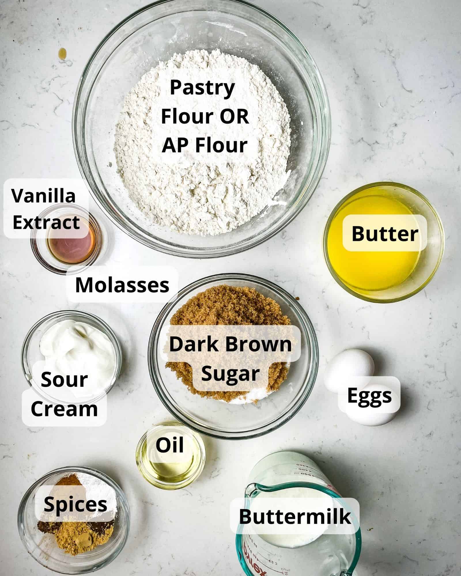 ingredients to make gingerbread muffins - pastry flour, butter, buttermilk, eggs, spices ,dark brown sugar, sugar, sour cream, oil, and vanilla extract.