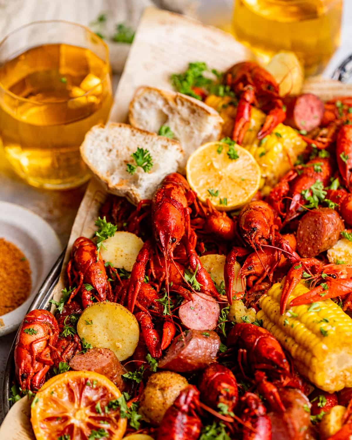 crawfish boil on a tray next to a glass of beer.