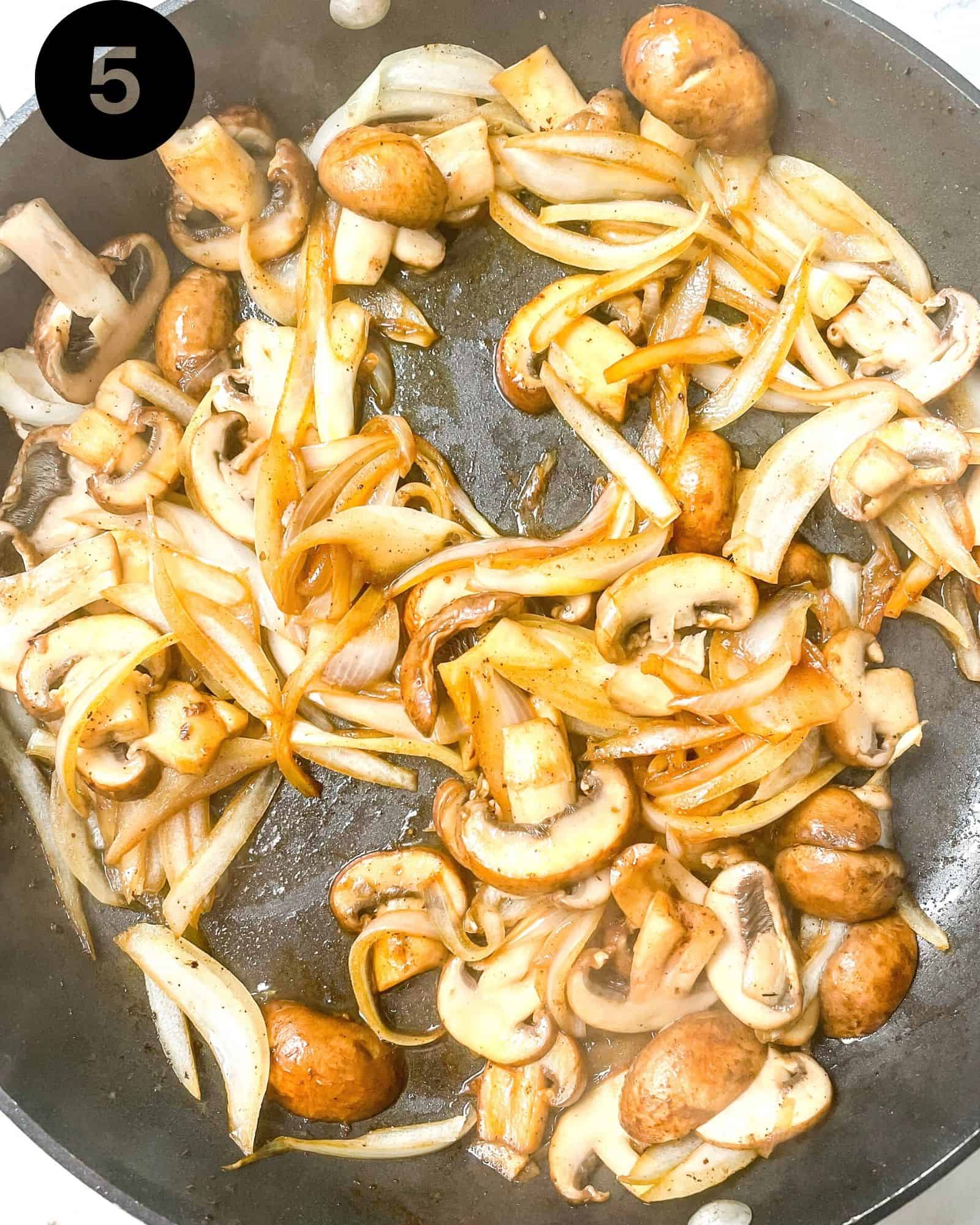 mushroom and onions sauteed in a skillet.