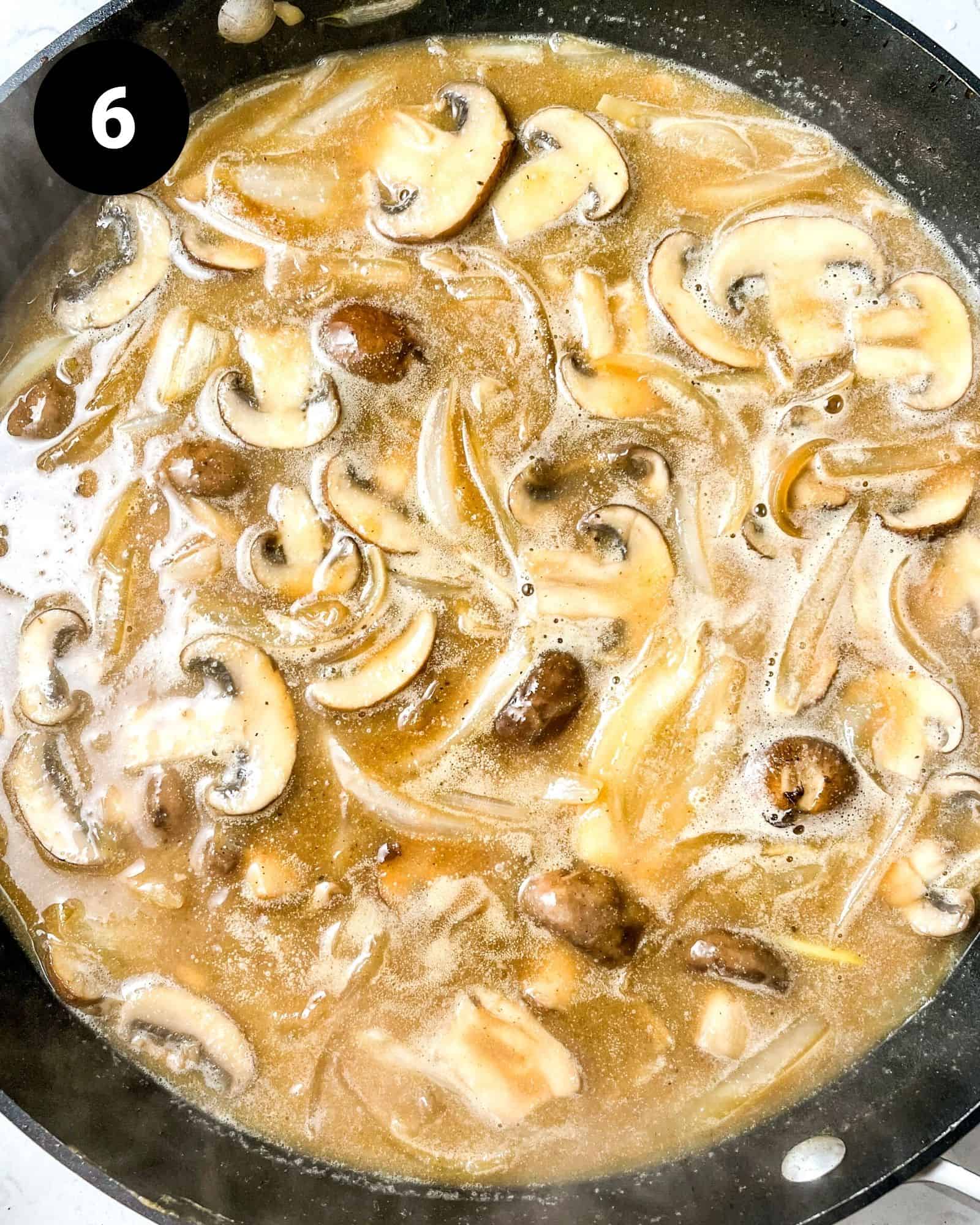mushrooms and onions in a pan with beef broth.