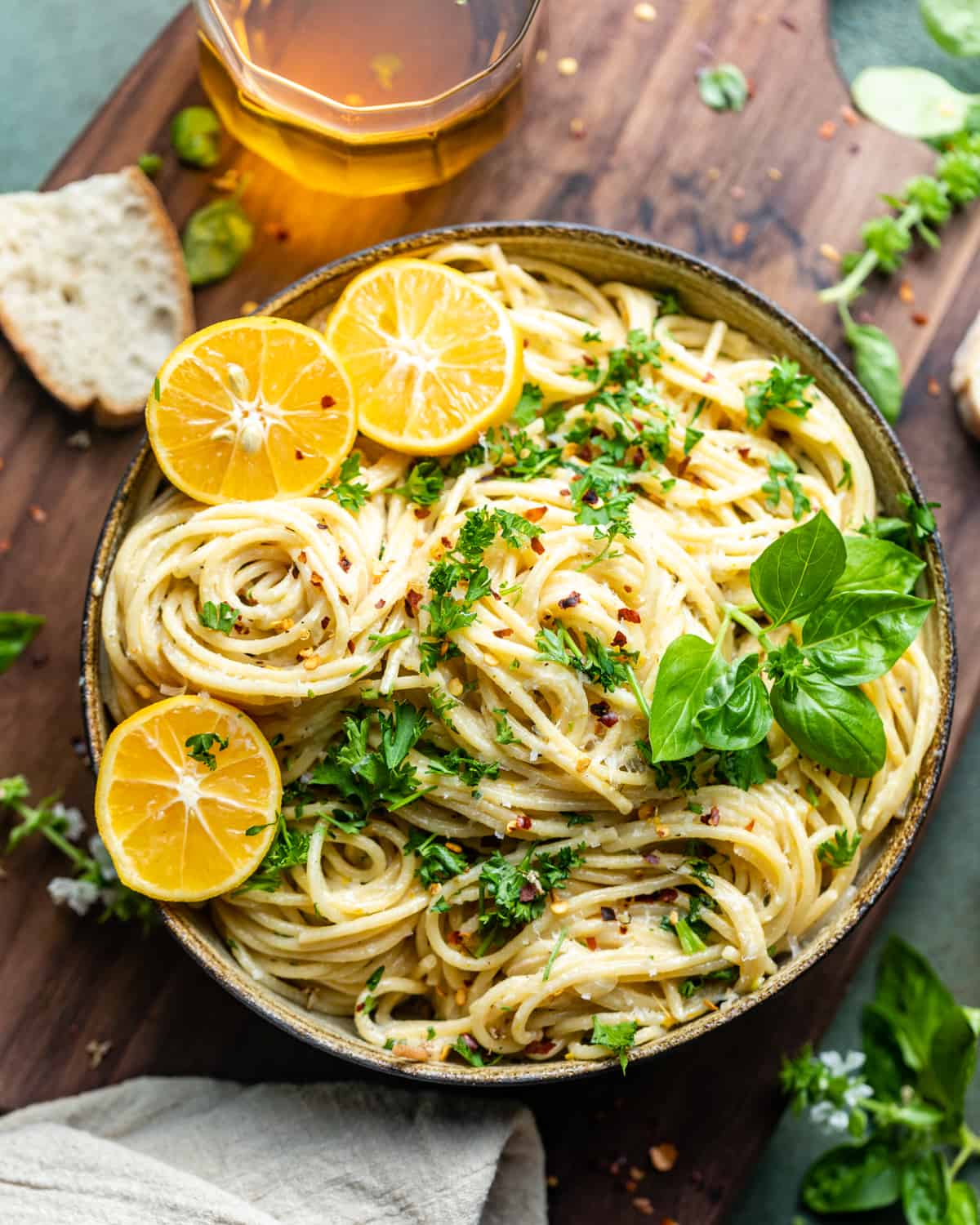 a bowl of lemon garlic pasta on top of a serving board.
